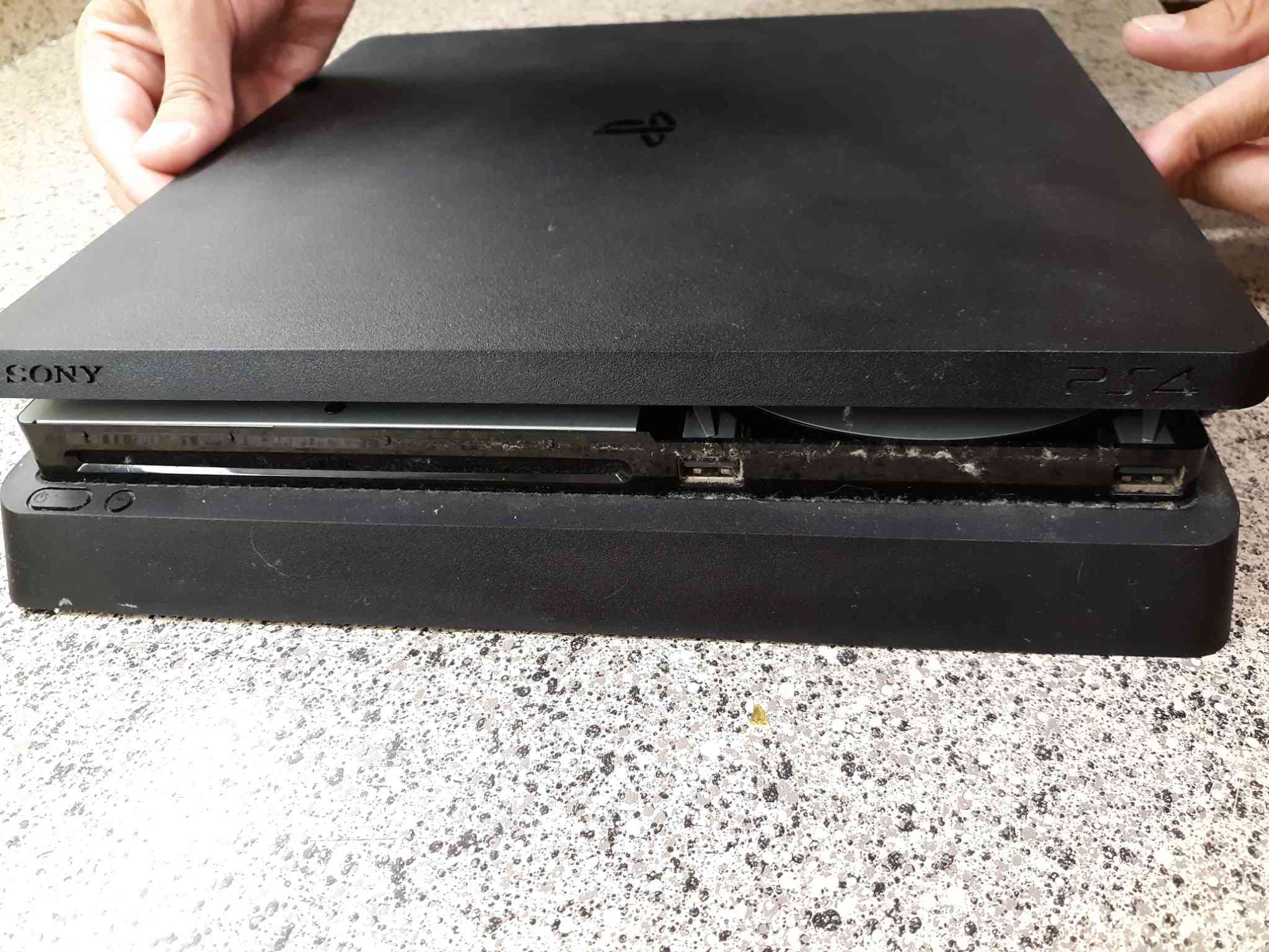 از قسمت زیرین کنسول زیر درپوش بالایی PS4 را بلند کنید تا محفظه خارجی آن جدا شود.